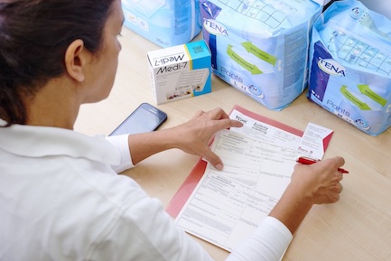 Betreuerin füllt Dokumente bezüglich ärztlicher und pflegerischer Tätigkeiten aus